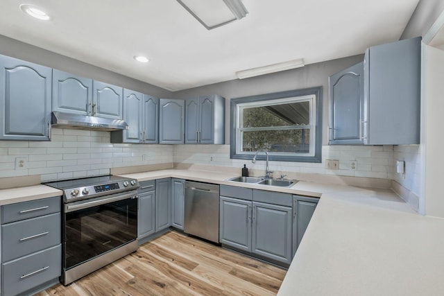 101 Walnut St, Smyrna, TN 37167 - kitchen featuring appliances with stainless steel finishes, under cabinet range hood, a sink, light wood-type flooring, and gray cabinets