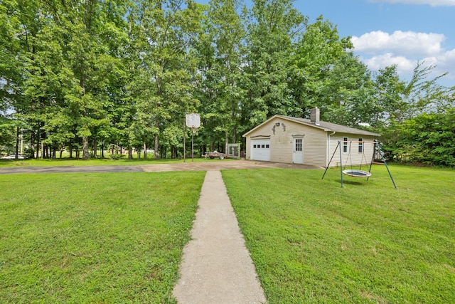 414 Ashe Ave, New Johnsonville, TN 37134 - view of green lawn with a detached garage, driveway, and view of wooded area