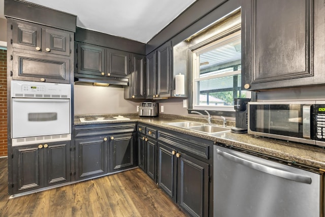 414 Ashe Ave, New Johnsonville, TN 37134 - kitchen featuring appliances with stainless steel finishes, a sink, dark wood finished floors, dark countertops, and under cabinet range hood