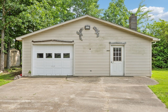 414 Ashe Ave, New Johnsonville, TN 37134 - view of front of property with an outbuilding, a detached garage, driveway, and a chimney