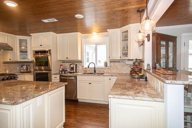 6684 Eudailey Covington Rd, College Grove, TN 37046 - kitchen featuring appliances with stainless steel finishes, a sink, a peninsula, under cabinet range hood, and wood ceiling