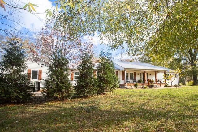 6684 Eudailey Covington Rd, College Grove, TN 37046 - ranch-style house with a porch and a front lawn