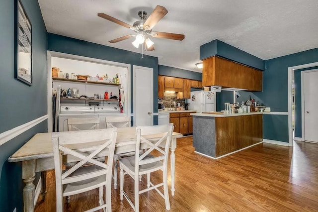 3225 Towne Village Rd E, Antioch, TN 37013 - kitchen featuring separate washer and dryer, white appliances, brown cabinets, a ceiling fan, and a peninsula