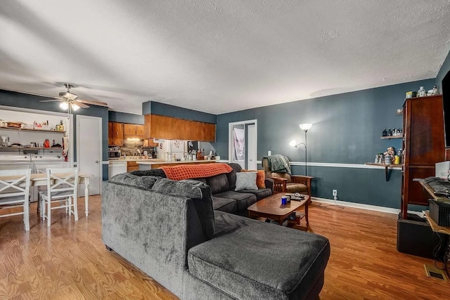3225 Towne Village Rd E, Antioch, TN 37013 - living area with light wood finished floors, ceiling fan, a textured ceiling, and baseboards