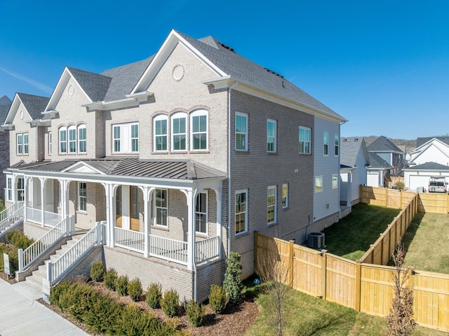 3174 Long Branch Cir, Franklin, TN 37064 - view of front facade with brick siding, covered porch, cooling unit, a standing seam roof, and a residential view