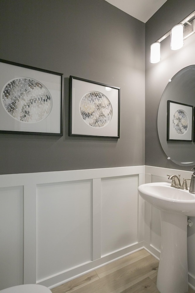 5047 Dayflower Dr, Hermitage, TN 37076 - bathroom featuring wood finished floors, a wainscoted wall, a decorative wall, and a sink