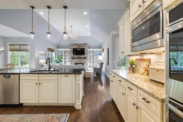 1825 Barnstaple Ln, Brentwood, TN 37027 - kitchen with stainless steel appliances, a sink, cream cabinets, a fireplace, and lofted ceiling