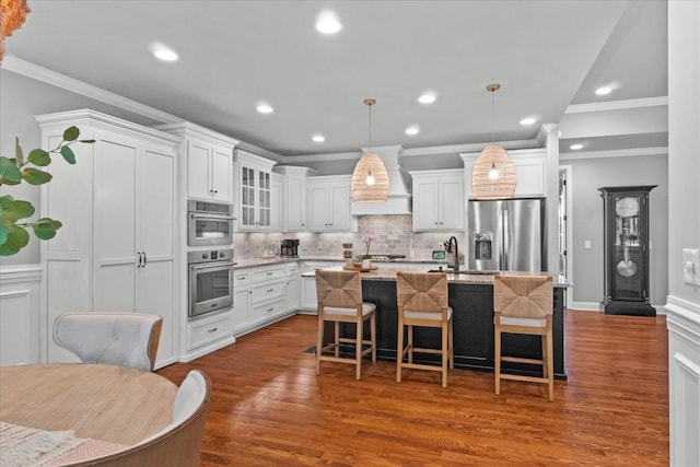 1076 Pretender Way, Columbia, TN 38401 - kitchen featuring appliances with stainless steel finishes, premium range hood, a center island with sink, tasteful backsplash, and white cabinets