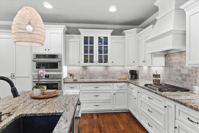 1076 Pretender Way, Columbia, TN 38401 - kitchen featuring a sink, wall chimney exhaust hood, stainless steel appliances, white cabinetry, and glass insert cabinets