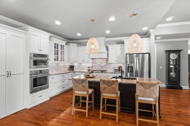 1076 Pretender Way, Columbia, TN 38401 - kitchen featuring appliances with stainless steel finishes, custom exhaust hood, a center island with sink, decorative backsplash, and white cabinets