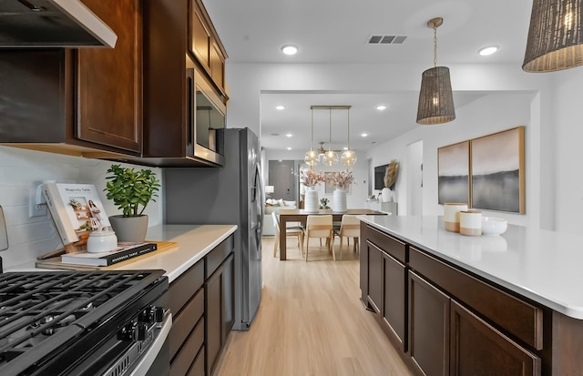 192 Sharp Way, Murfreesboro, TN 37128 - kitchen with stainless steel microwave, gas range oven, light wood-type flooring, light countertops, and exhaust hood