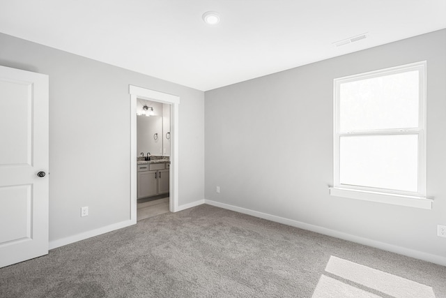 2655 Burton Dr, White House, TN 37188 - unfurnished bedroom with light carpet, baseboards, a sink, and ensuite bath