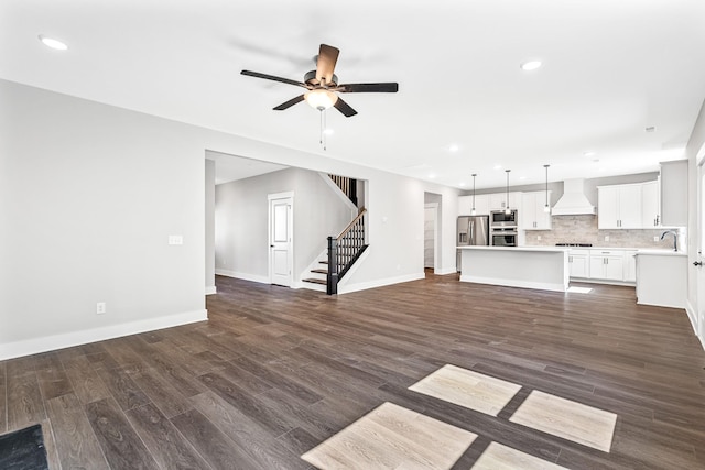 2655 Burton Dr, White House, TN 37188 - unfurnished living room with ceiling fan, recessed lighting, dark wood-style flooring, stairway, and a sink