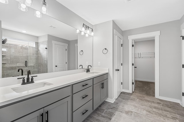 2655 Burton Dr, White House, TN 37188 - bathroom with double vanity, a stall shower, wood finished floors, a walk in closet, and baseboards
