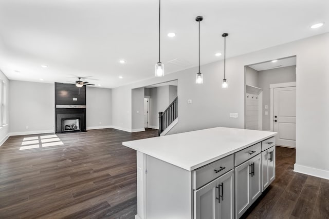 2655 Burton Dr, White House, TN 37188 - kitchen with a ceiling fan, baseboards, dark wood-style floors, a center island, and light countertops