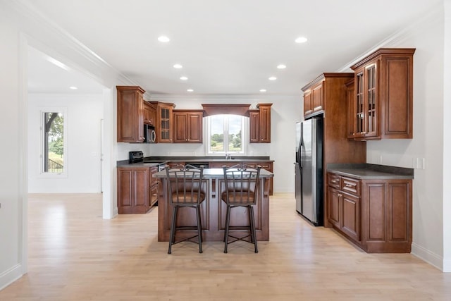 254 Davis Rd, Lebanon, TN 37087 - kitchen featuring appliances with stainless steel finishes, dark countertops, light wood-style flooring, a kitchen bar, and plenty of natural light