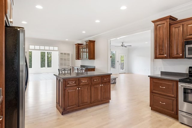 254 Davis Rd, Lebanon, TN 37087 - kitchen featuring stainless steel appliances, dark countertops, open floor plan, light wood-style flooring, and ceiling fan