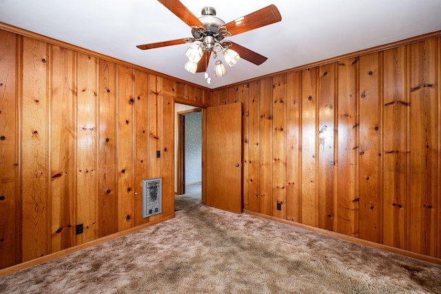 924 Shauna Dr, Nashville, TN 37214 - empty room with heating unit, carpet flooring, wood walls, a ceiling fan, and crown molding