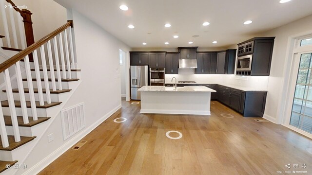 2408 Oakmont Ln, Mount Juliet, TN 37122 - kitchen with stainless steel appliances, under cabinet range hood, light wood-type flooring, recessed lighting, and a center island with sink