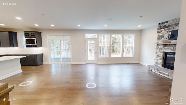 2408 Oakmont Ln, Mount Juliet, TN 37122 - unfurnished living room with wood finished floors, a stone fireplace, recessed lighting, and baseboards