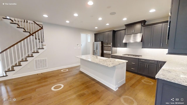 2408 Oakmont Ln, Mount Juliet, TN 37122 - kitchen featuring under cabinet range hood, stainless steel appliances, light wood finished floors, baseboards, and a kitchen island