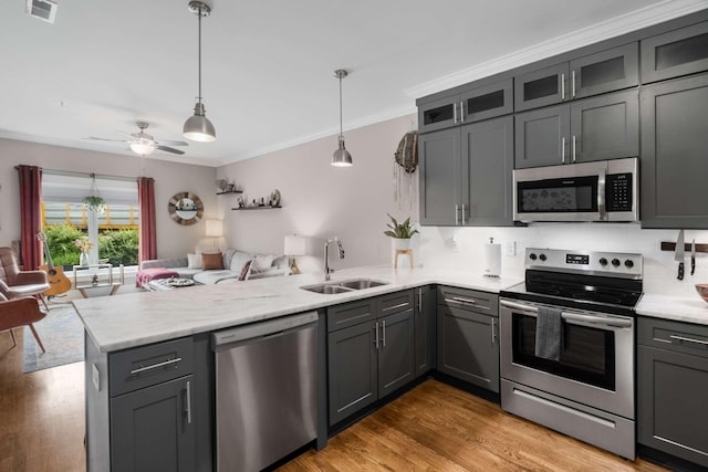 3303 Gallatin Pike Unit 202, Nashville, TN 37216 - kitchen featuring stainless steel appliances, a sink, a peninsula, open floor plan, and ornamental molding