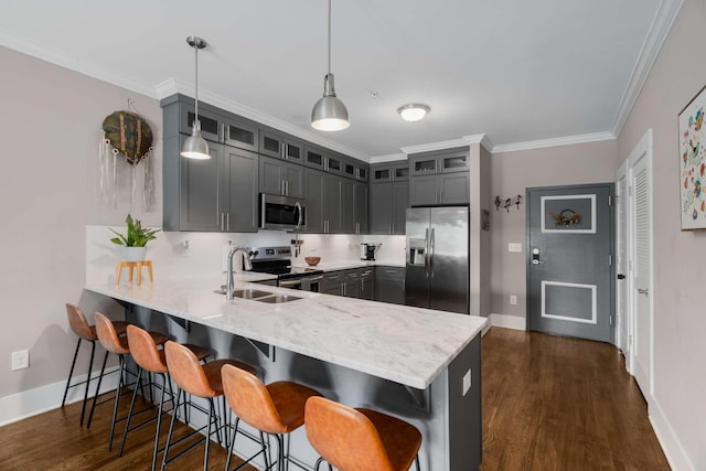3303 Gallatin Pike Unit 202, Nashville, TN 37216 - kitchen featuring appliances with stainless steel finishes, a peninsula, dark wood-type flooring, baseboards, and a kitchen breakfast bar
