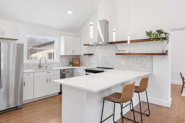408 Adair Rd, Nashville, TN 37214 - kitchen with stainless steel appliances, a sink, wall chimney exhaust hood, a breakfast bar area, and a peninsula