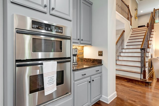 106 Ashton Park Blvd, Franklin, TN 37067 - kitchen featuring stainless steel double oven, dark wood-style floors, decorative backsplash, baseboards, and dark stone counters