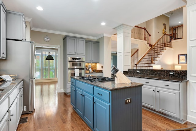 106 Ashton Park Blvd, Franklin, TN 37067 - kitchen with a center island, gas cooktop, crown molding, blue cabinets, and wood finished floors