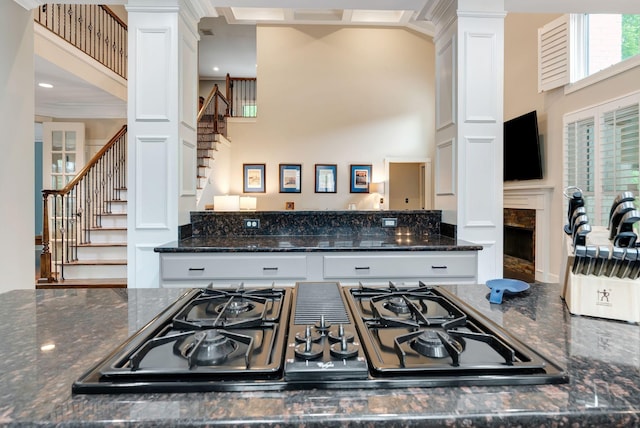 106 Ashton Park Blvd, Franklin, TN 37067 - kitchen with black gas cooktop, a high ceiling, white cabinets, dark stone countertops, and a fireplace