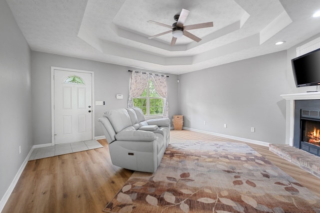 97 Whitefield Ln, Carthage, TN 37030 - living room featuring wood finished floors, a tray ceiling, a fireplace, and ceiling fan