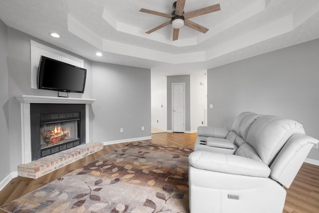 97 Whitefield Ln, Carthage, TN 37030 - living room featuring a ceiling fan, wood finished floors, a tray ceiling, baseboards, and a fireplace