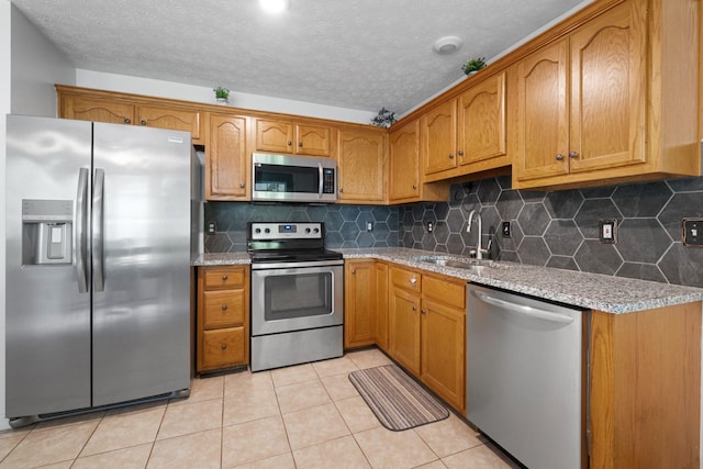 97 Whitefield Ln, Carthage, TN 37030 - kitchen with appliances with stainless steel finishes, a sink, brown cabinetry, backsplash, and a textured ceiling