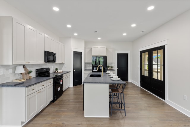 312 N Main St, Dickson, TN 37055 - kitchen featuring black appliances, a sink, dark countertops, backsplash, and recessed lighting