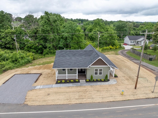 312 N Main St, Dickson, TN 37055 - view of front facade featuring covered porch, a forest view, and a shingled roof