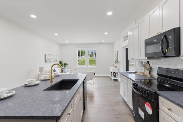 312 N Main St, Dickson, TN 37055 - kitchen with black appliances, a sink, dark countertops, wood finished floors, and recessed lighting
