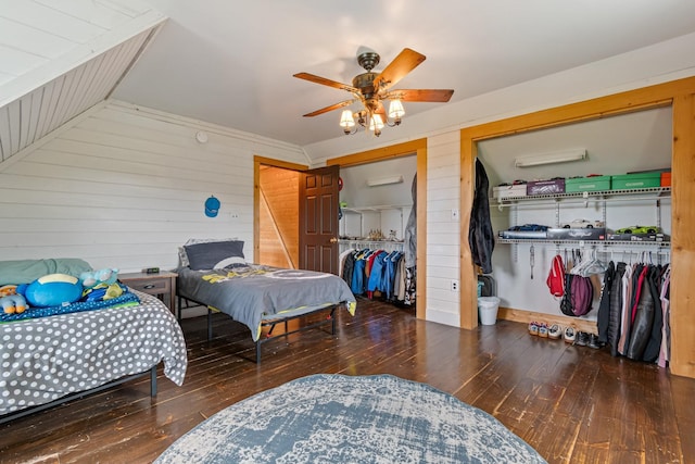 2223 Simmons Ridge Rd, Cornersville, TN 37047 - bedroom featuring two closets, hardwood / wood-style floors, wood walls, vaulted ceiling, and a ceiling fan