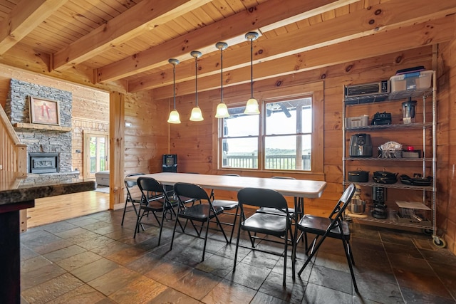 2223 Simmons Ridge Rd, Cornersville, TN 37047 - dining room featuring stone tile flooring, wooden ceiling with exposed beams, wood walls, and a stone fireplace