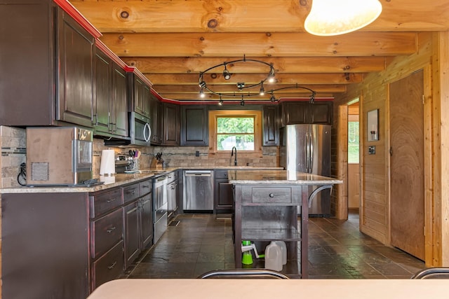 2223 Simmons Ridge Rd, Cornersville, TN 37047 - kitchen featuring appliances with stainless steel finishes, decorative backsplash, beam ceiling, light stone countertops, and a kitchen island