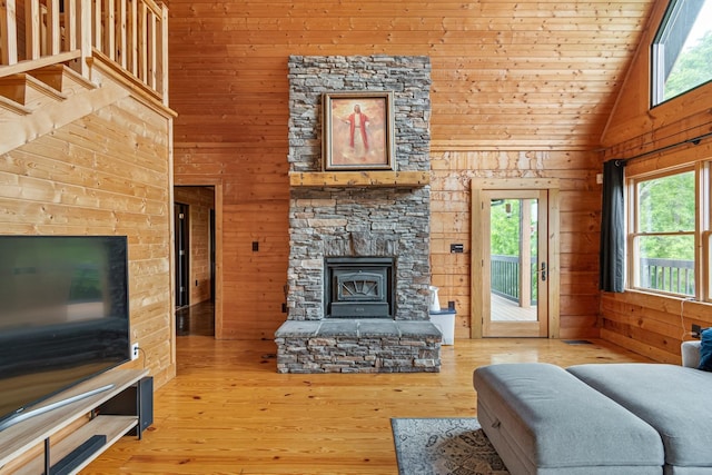 2223 Simmons Ridge Rd, Cornersville, TN 37047 - living area with wooden walls, plenty of natural light, a stone fireplace, high vaulted ceiling, and light wood-type flooring