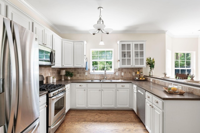 3113 Friars Bridge Pass, Franklin, TN 37064 - kitchen with stainless steel appliances, a peninsula, dark countertops, white cabinetry, and a sink