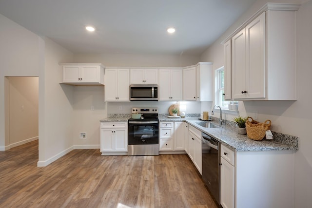766 Billy Wynn Rd, Dickson, TN 37055 - kitchen featuring appliances with stainless steel finishes, a sink, light wood-style flooring, white cabinetry, and recessed lighting