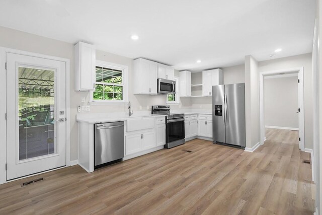 4044 Brick Church Pike, Nashville, TN 37207 - kitchen with stainless steel appliances, white cabinets, light wood finished floors, light countertops, and recessed lighting