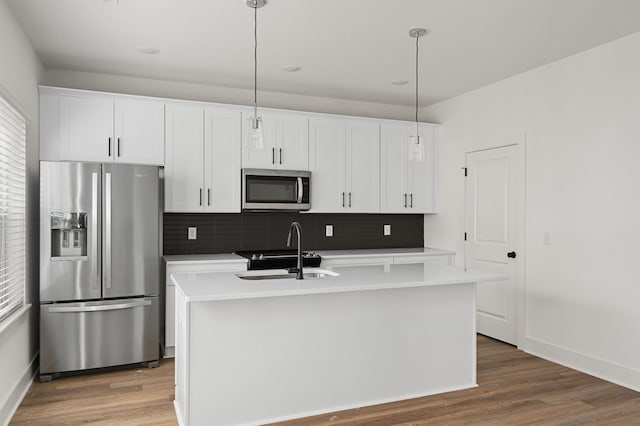 718 N Dupont Ave, Madison, TN 37115 - kitchen with appliances with stainless steel finishes, a sink, decorative backsplash, a center island with sink, and white cabinets