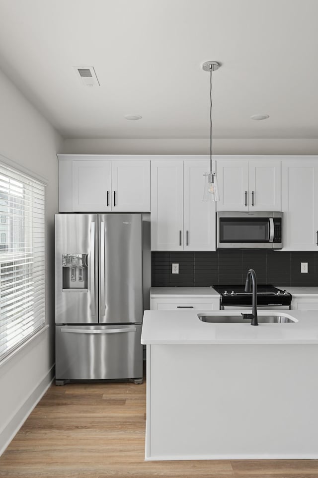 718 N Dupont Ave, Madison, TN 37115 - kitchen with appliances with stainless steel finishes, tasteful backsplash, white cabinetry, and light wood-type flooring