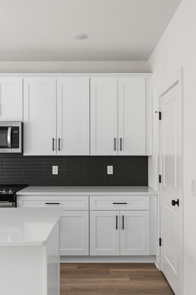 718 N Dupont Ave, Madison, TN 37115 - kitchen with appliances with stainless steel finishes, white cabinets, light countertops, wood finished floors, and tasteful backsplash