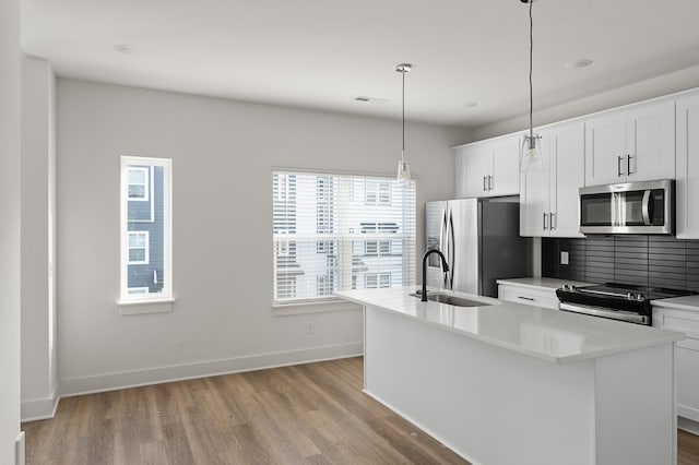 718 N Dupont Ave, Madison, TN 37115 - kitchen featuring appliances with stainless steel finishes, a sink, a kitchen island with sink, light wood-style floors, and tasteful backsplash