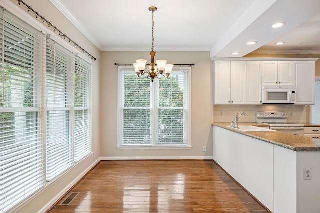 517 Ridgestone Dr, Franklin, TN 37064 - kitchen featuring white appliances, a sink, a chandelier, ornamental molding, and white cabinetry