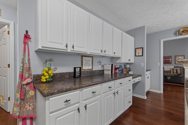 373 Baronswood Dr, Nolensville, TN 37135 - kitchen featuring dark wood-style flooring, dark countertops, white cabinetry, a textured ceiling, and baseboards